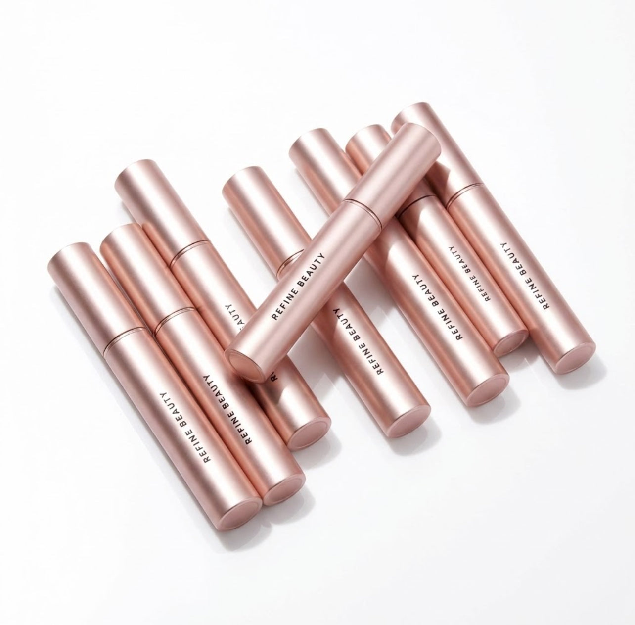 Refine Beauty Volume mascaras tubes on white background 