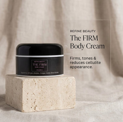 Black jar of Refine Beauty The Firm body cream on a beige stone block with text about its benefits.