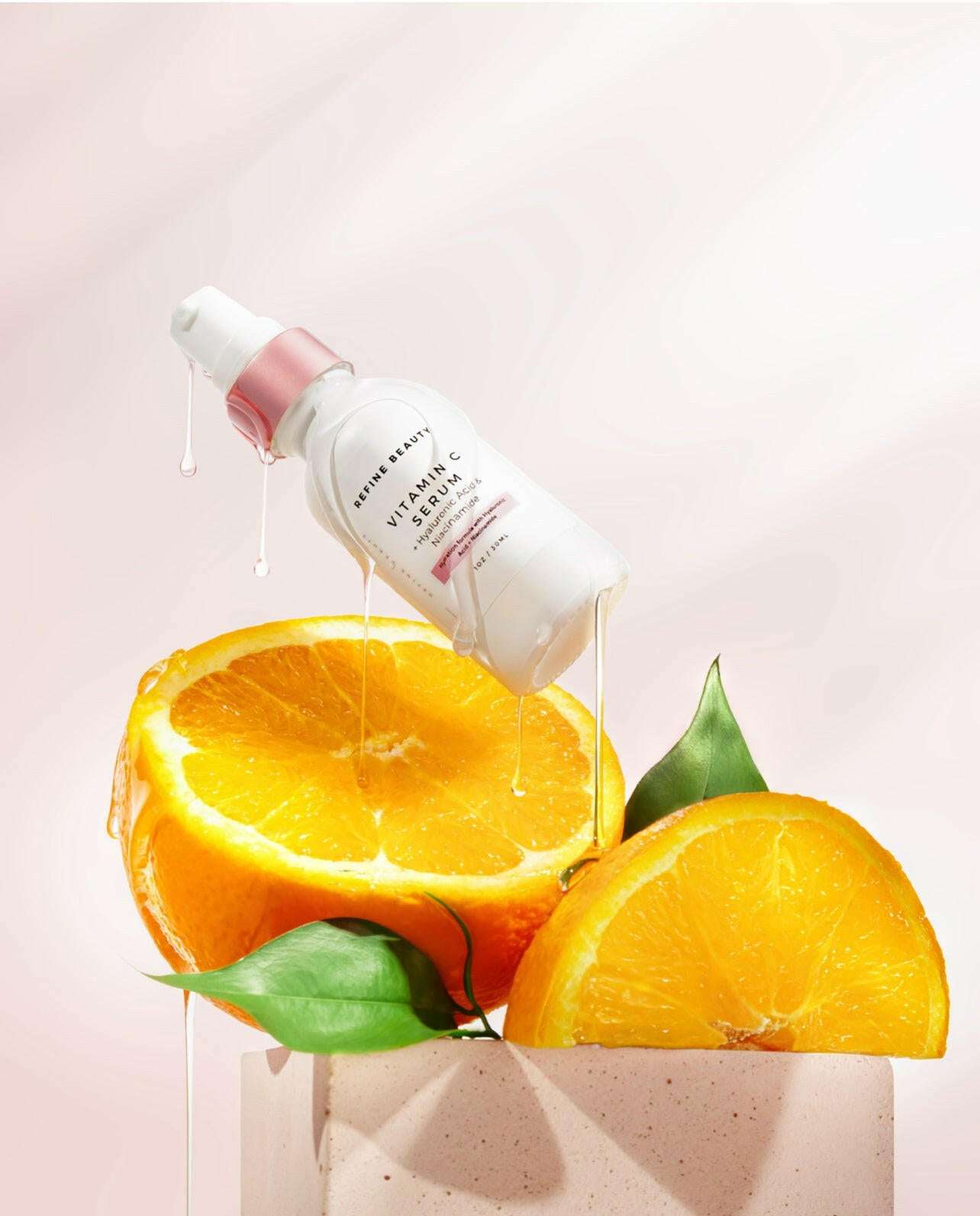 Vitamin C Serum with Hyaluronic Acid + Niacinamide on top of oranges