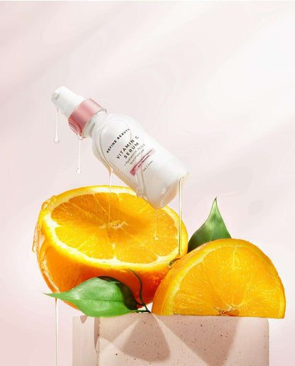 Vitamin C Serum with Hyaluronic Acid + Niacinamide on top of oranges