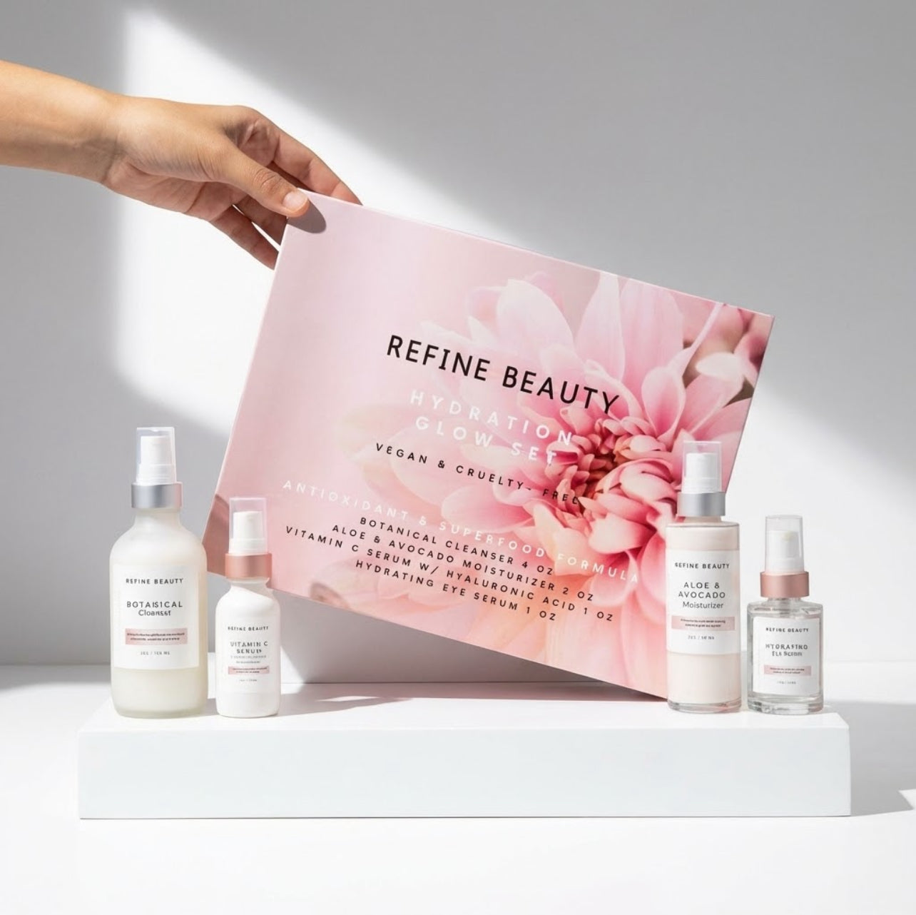 Refine Beauty Hydration GLOW set with bottles and a pink packaging box on a white surface.