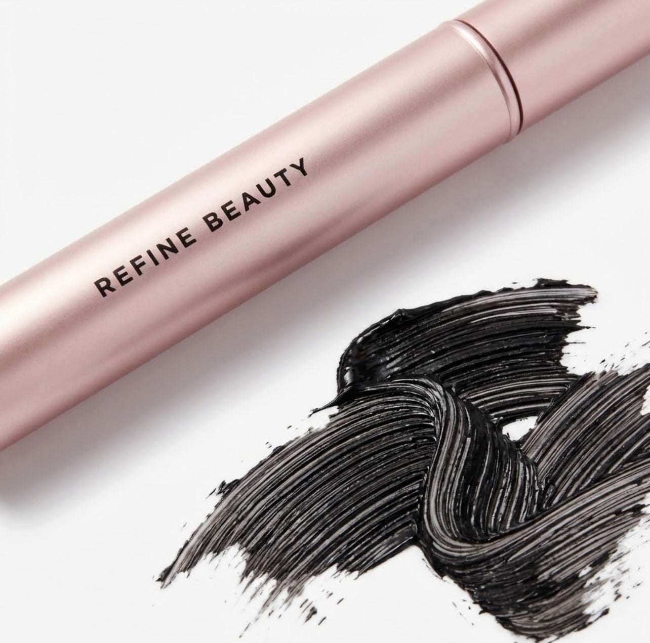 Refine Beauty Volume mascara  Tube and black makeup swatch on a white background