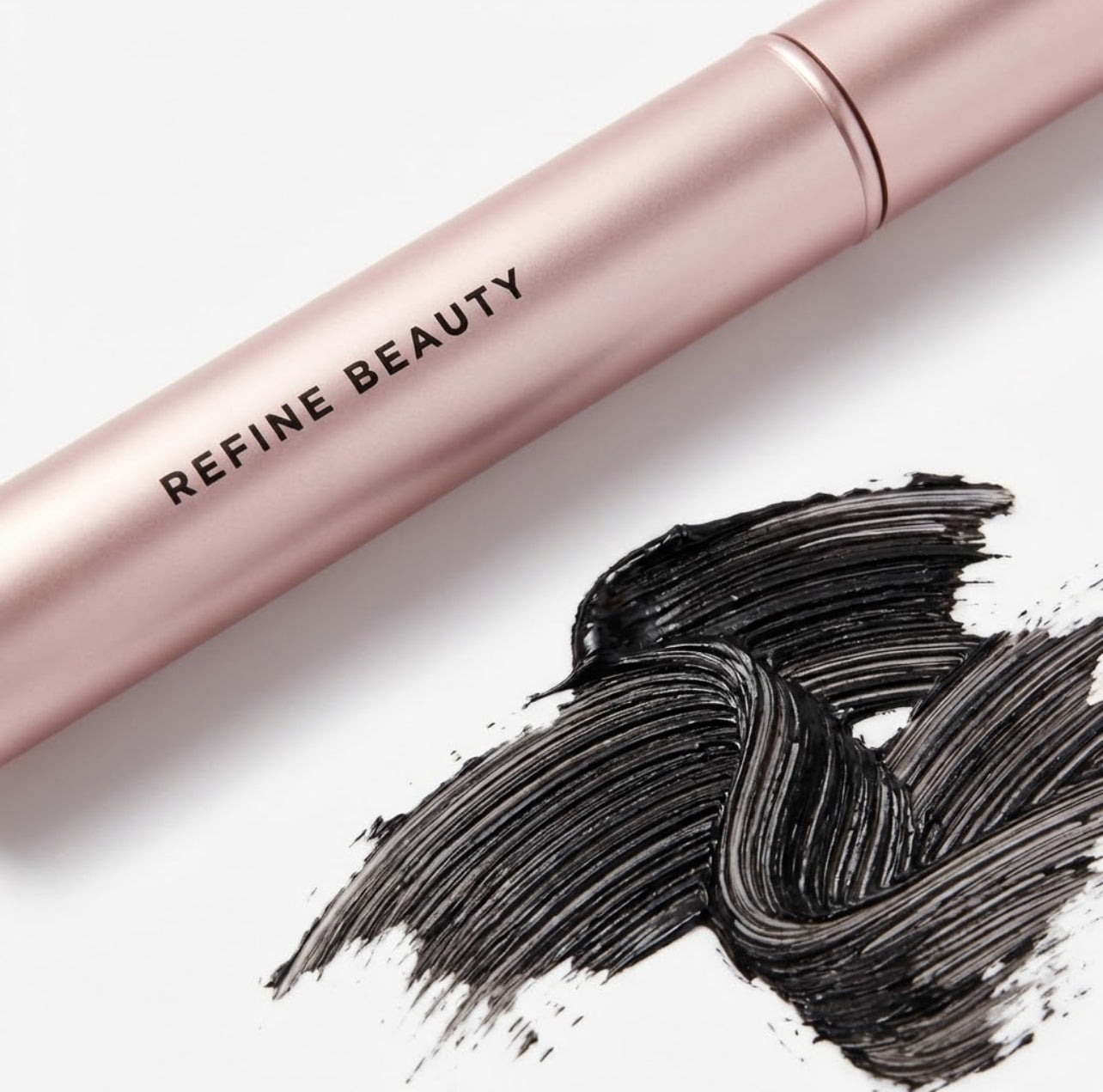 Refine Beauty Volume mascara  Tube and black makeup swatch on a white background