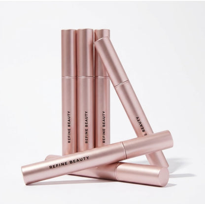 Rose gold mascara beauty products with Refine Beauty branding on a white background