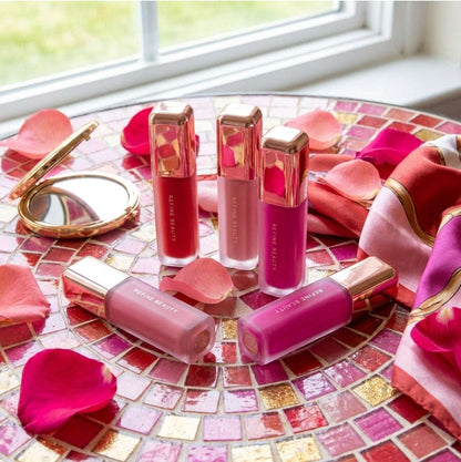 Set of pink Refine Beauty blushes on a mosaic table with rose petals