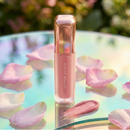 Refine Beauty blush on a reflective surface with flower petals.