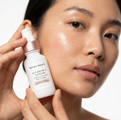 Person holding a Refine Beauty Vitamin C serum bottle with a neutral background