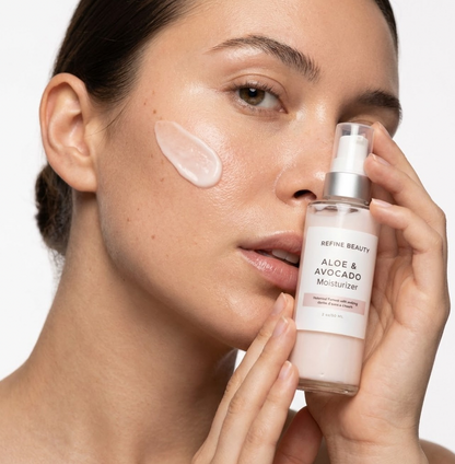 Woman applying Refine Beauty aloe and avocado moisturizer to her face with a close-up of the product.
